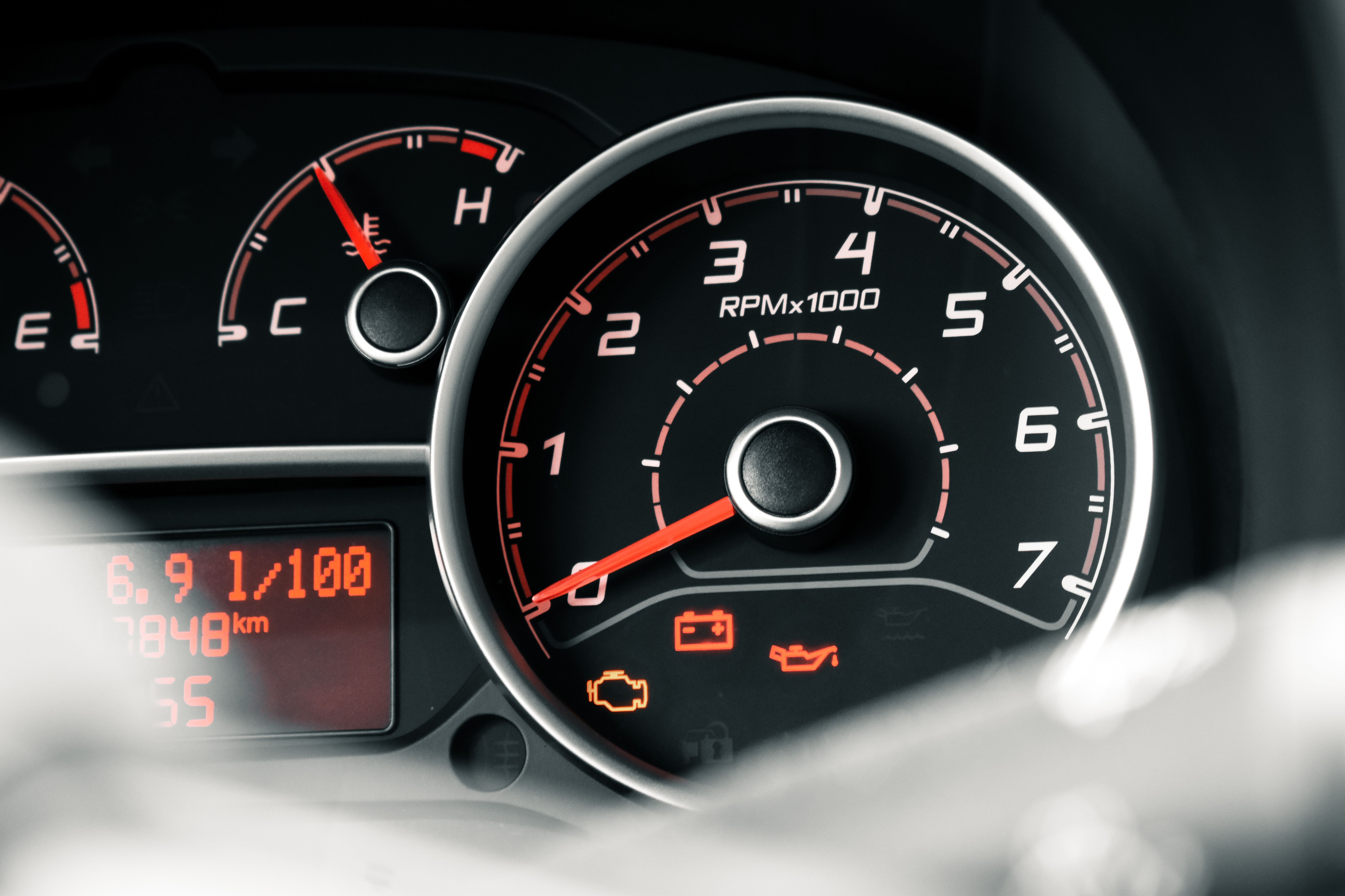 Car dashboard showing illuminated battery warning light